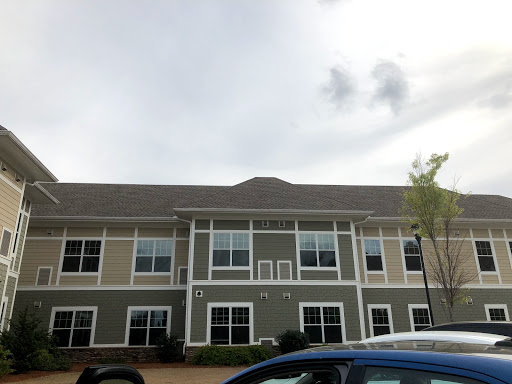 A modern multi-family residential building under a cloudy sky.