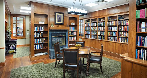 A cozy library with wooden interiors, shelves filled with books, and a comfortable reading area.
