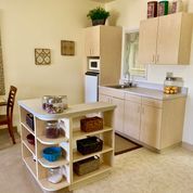 A modern kitchen with a central island featuring open shelves.
