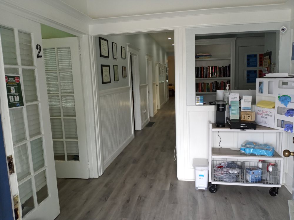 A view of the interior hallway in an office with a reception area and brochures on display.