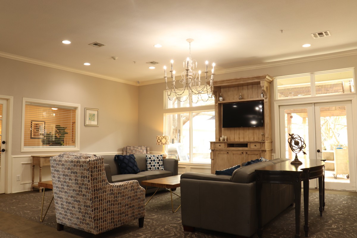 A cozy living room with elegant furnishings and a chandelier.