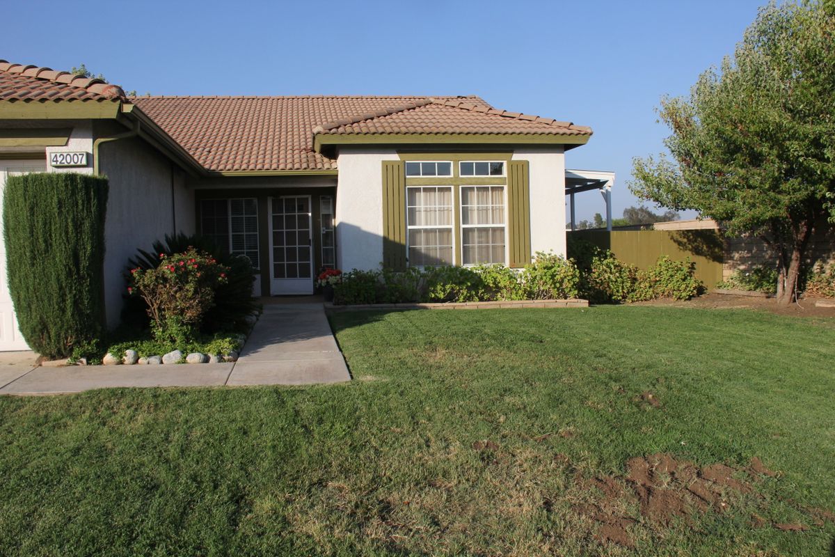 A suburban house with a well-maintained lawn and garden.