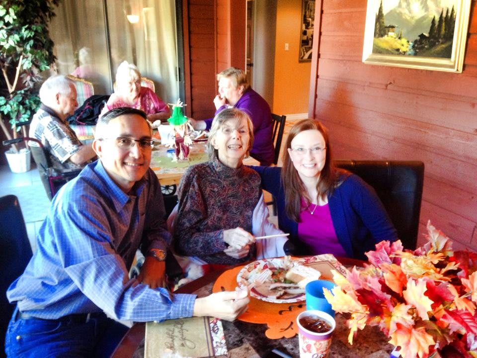A group of people enjoying a meal together indoors, smiling and celebrating togetherness.