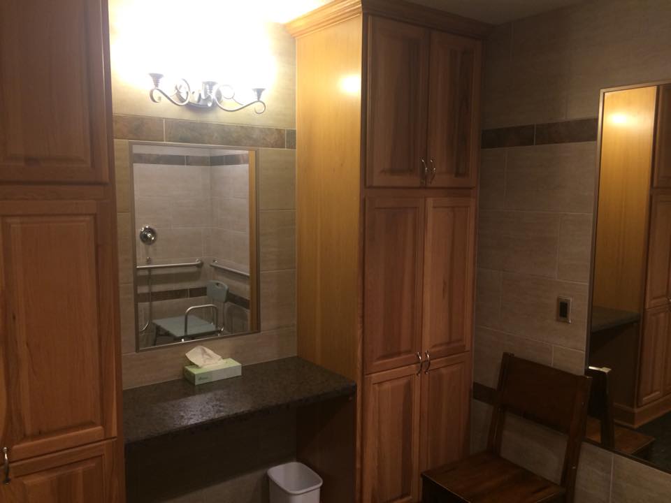 A bathroom featuring a mirror, sink, and wooden cabinets under soft lighting.