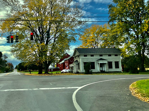 A picturesque rural intersection showcasing vibrant fall colors and a mix of charming houses.