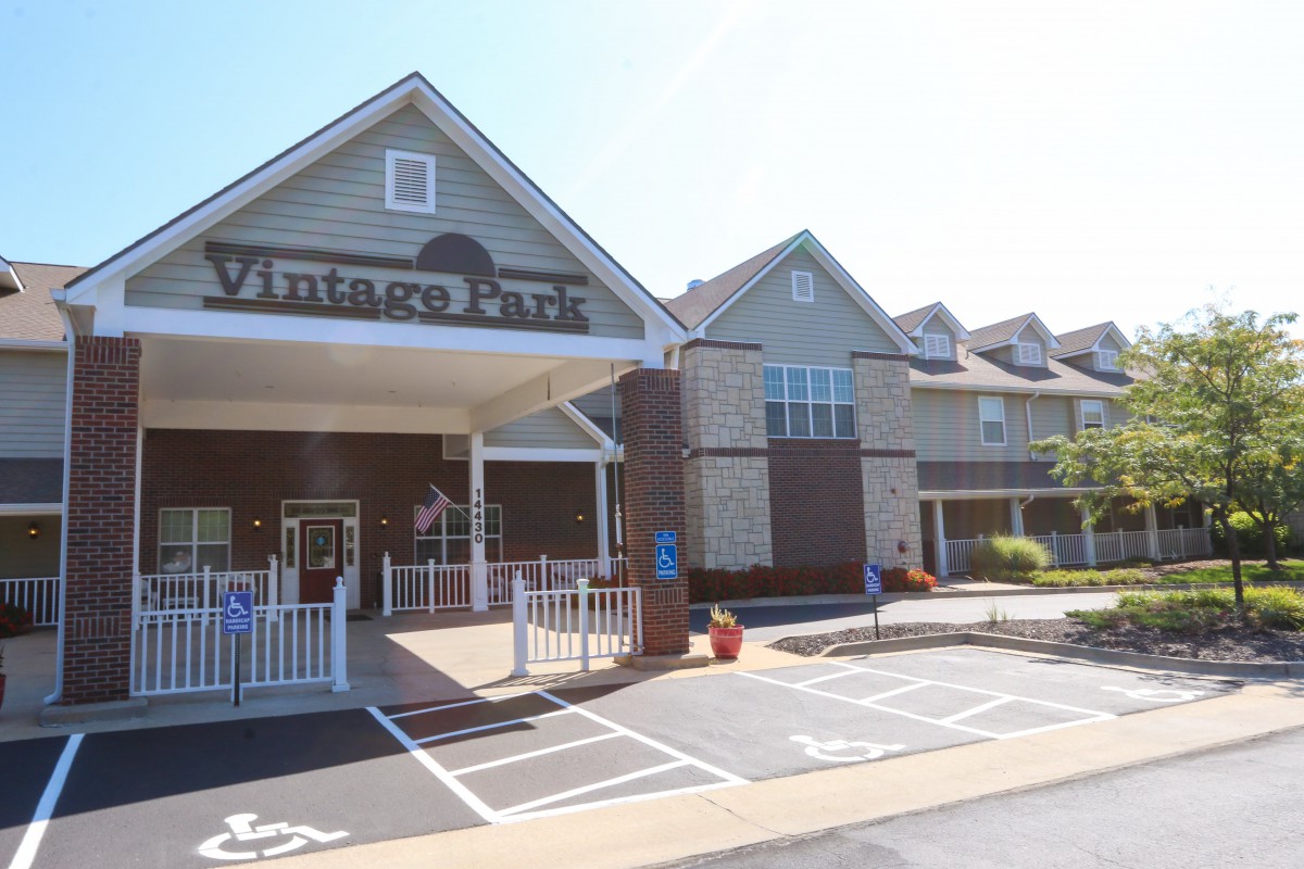 A building with a covered entrance and adjacent parking spaces.