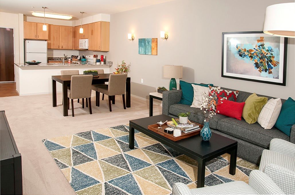 A modern open-concept living and dining area with a cozy sofa, coffee table, dining set, and stylish decor.