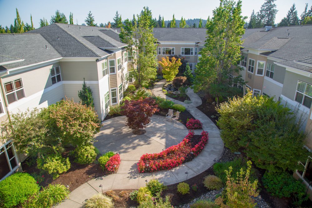 A beautifully landscaped garden with a winding pathway in an apartment complex.