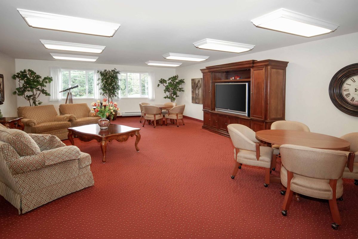 A spacious living room with comfortable seating, a large television, and natural light.