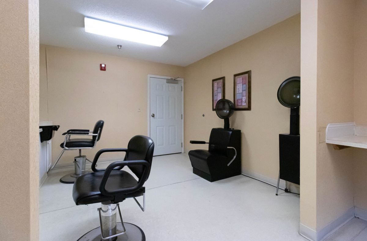 An empty salon with chairs and hair dryers ready for clients.