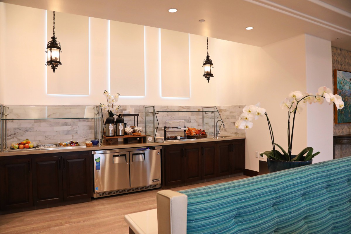 A modern kitchen interior with a sleek design, featuring stainless steel appliances and elegant lighting.