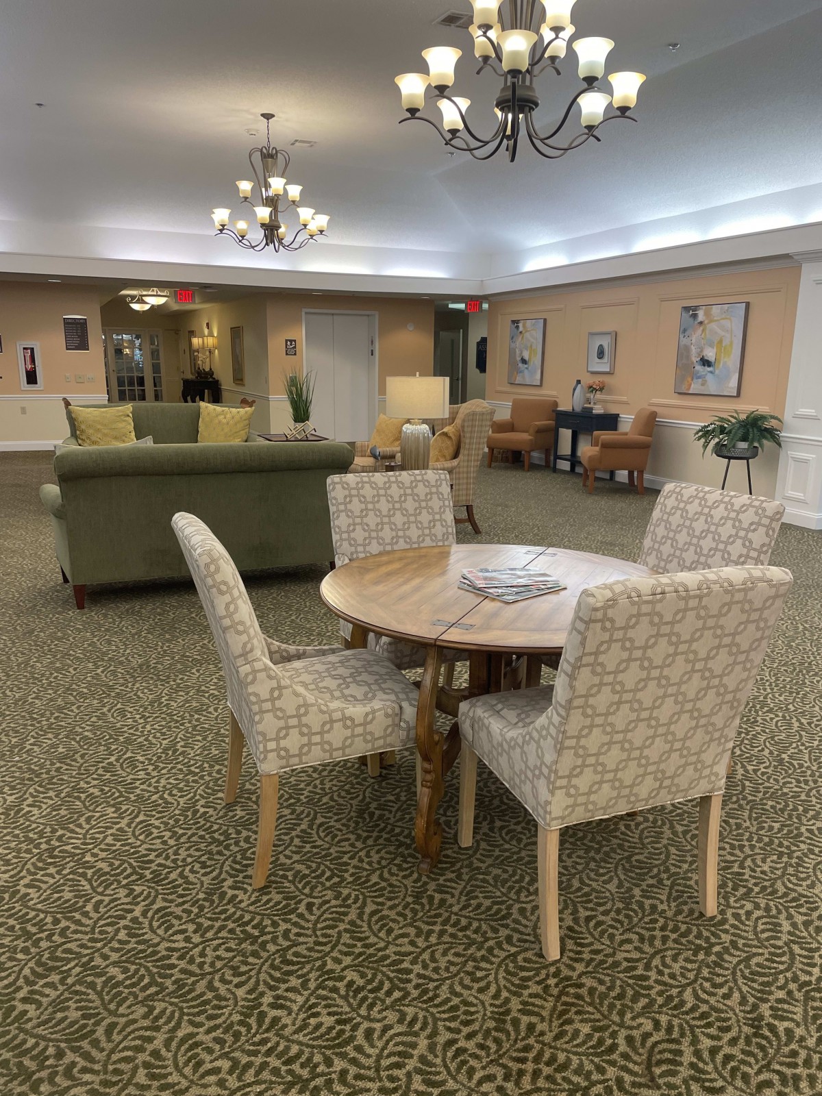 A cozy lobby area featuring a round table with chairs and a comfortable sofa.