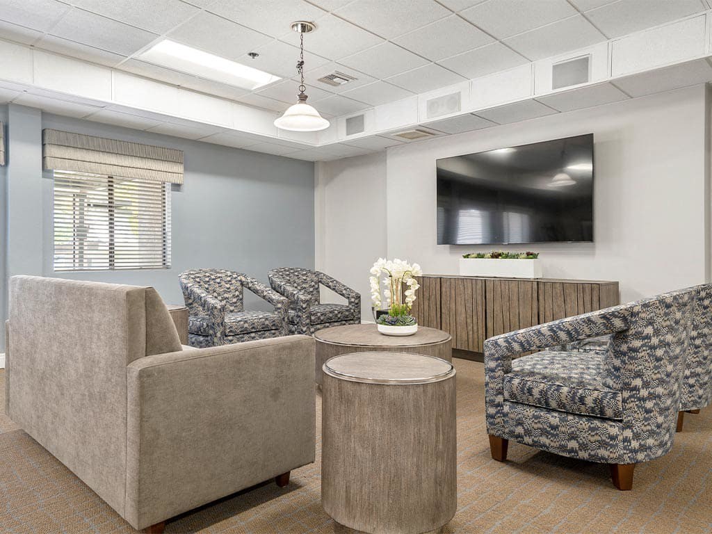 A modern living room with comfortable seating, a large television, and elegant decor in neutral tones.