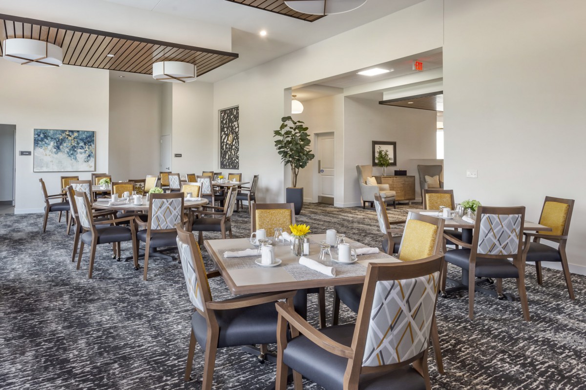 A modern dining area with neatly arranged tables and chairs, featuring stylish interior design and comfortable seating.