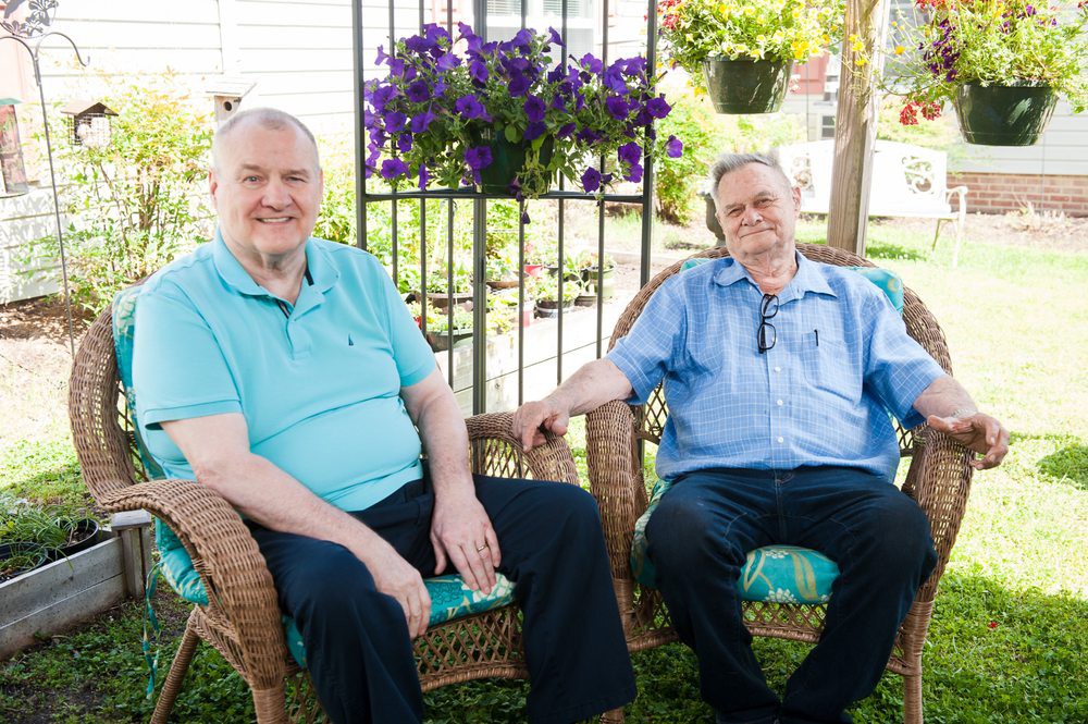 Two people sitting outside in a garden setting.