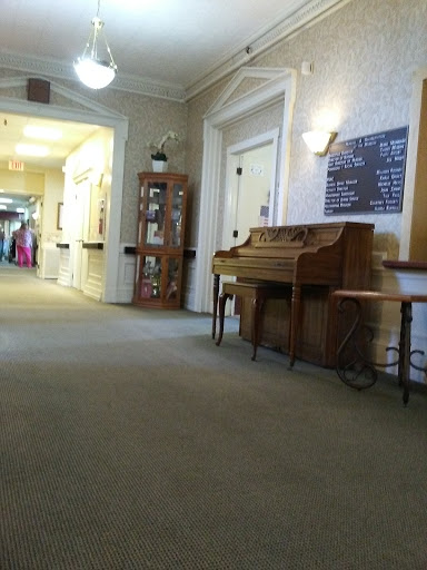 A serene hallway featuring a piano and warm decor, inviting a sense of calm.