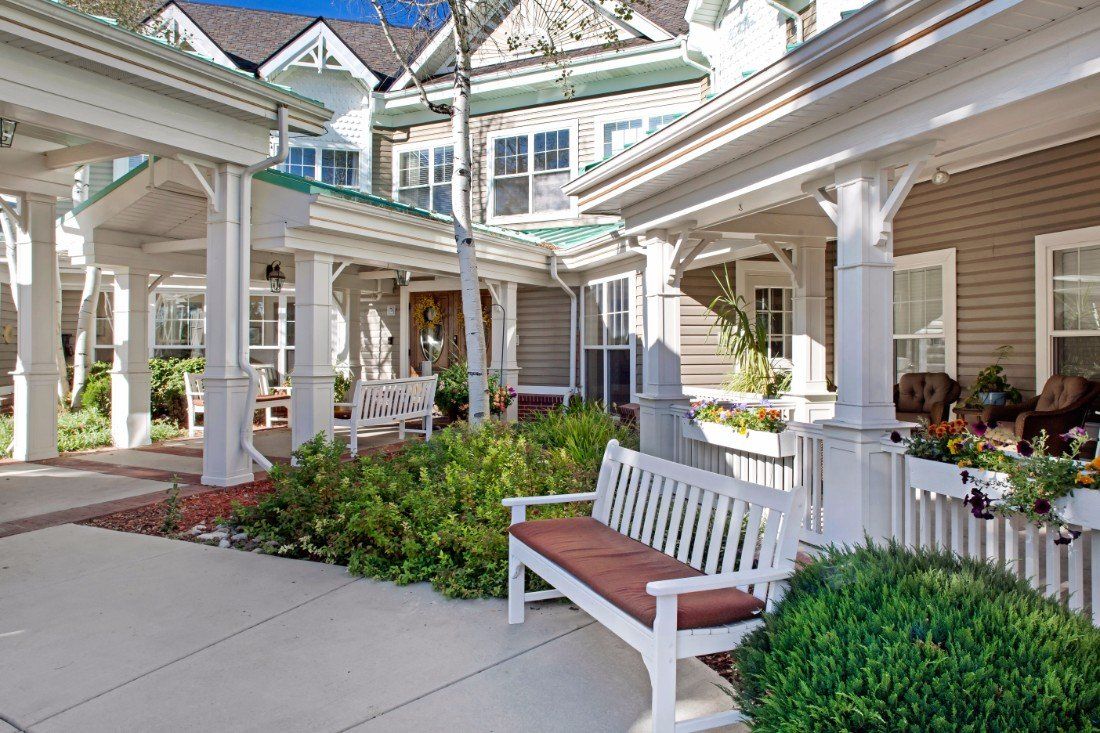 Charming courtyard with benches and greenery in front of a residential building.