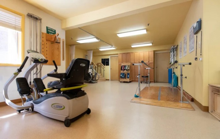 A rehabilitation room equipped with fitness and therapy equipment.