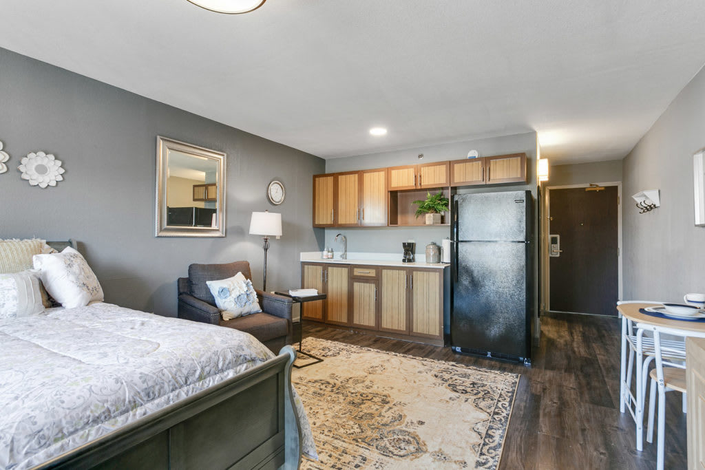 A modern studio apartment featuring a compact kitchen and cozy living area.