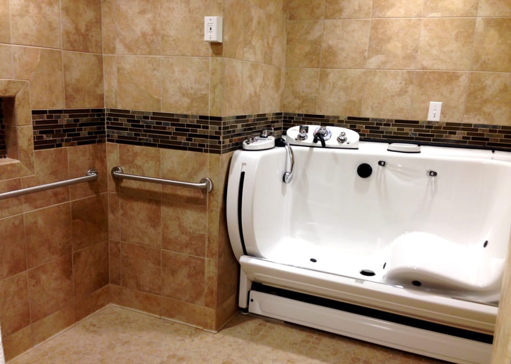 An accessible bathroom featuring a walk-in tub and grab bars for safety.