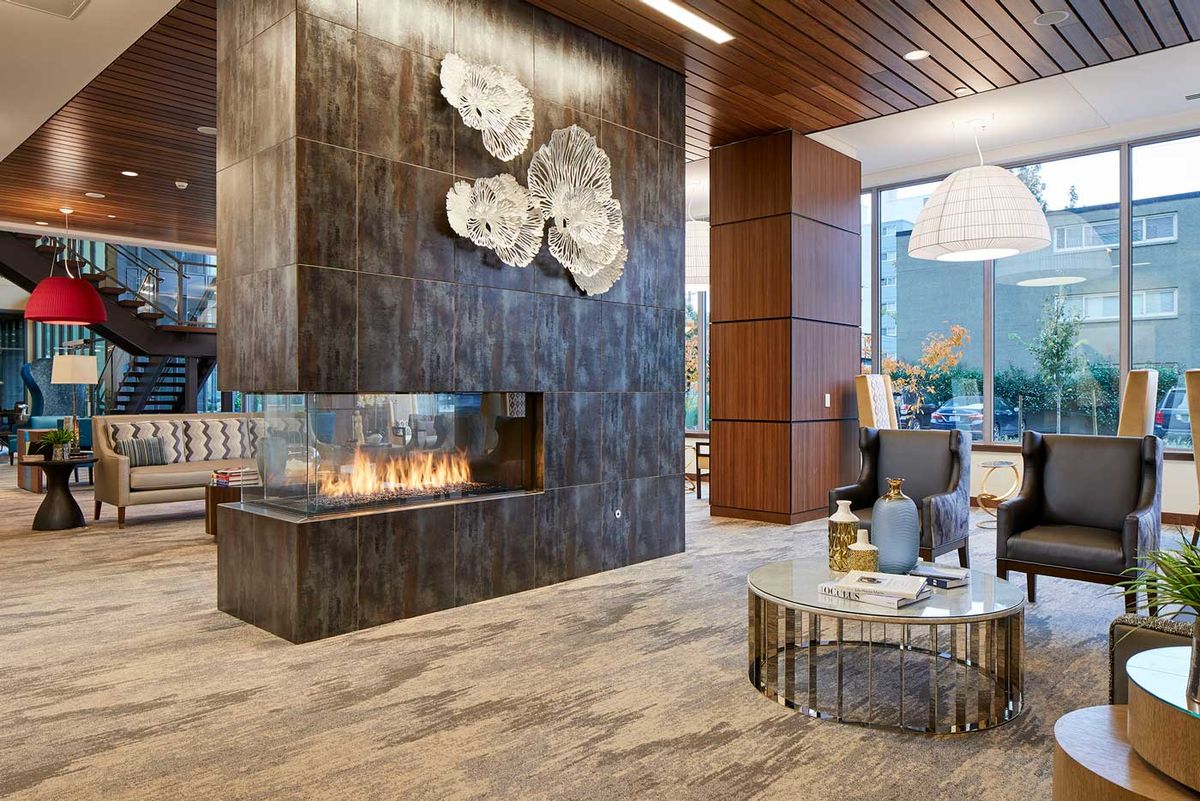 A modern lobby with a sleek fireplace and stylish seating area.