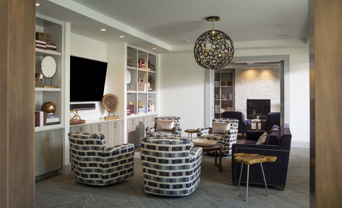 A modern living room featuring stylish furniture and a large TV.
