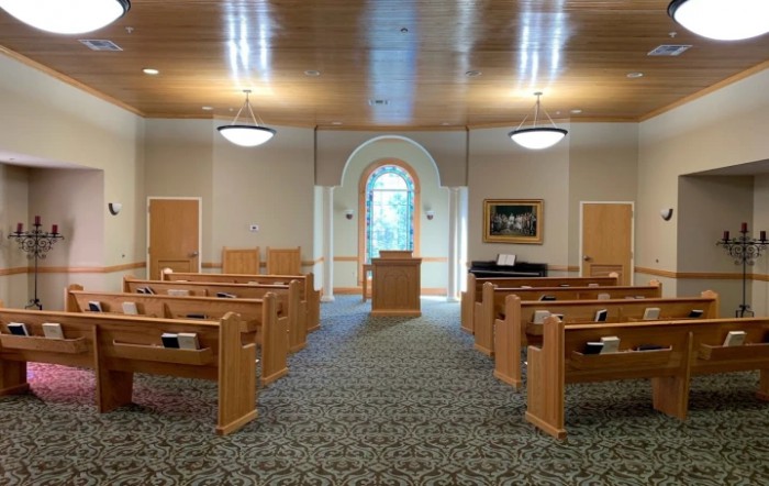 Interior view of a chapel with wooden pews and a central pulpit.