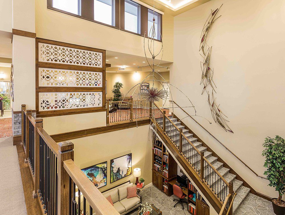 A modern home interior featuring a spacious open design with a staircase and artistic wall decor.