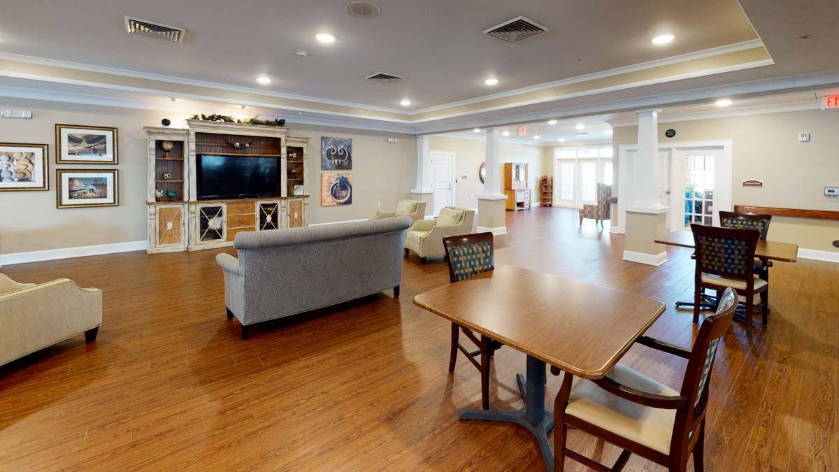 A spacious living area with a television, comfortable seating, and hardwood flooring.