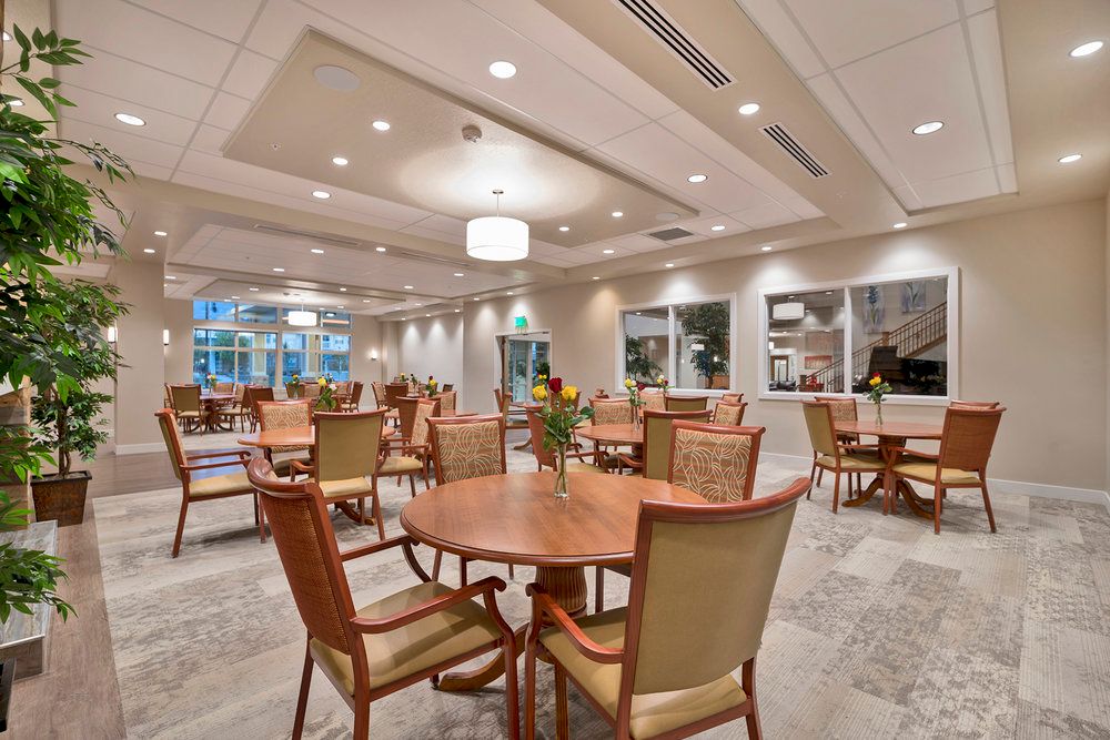 A spacious and well-lit dining area with neatly arranged tables and chairs.