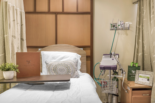 A well-equipped hospital patient room featuring a comfortable bed and essential medical devices.