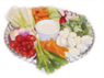 A vegetable platter with a variety of fresh veggies and a dip in the center.