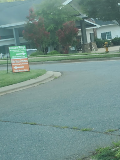 A view of a street corner with signage and landscaped grass.