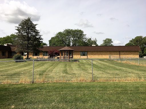 A picturesque view of a building surrounded by well-maintained grass and trees.