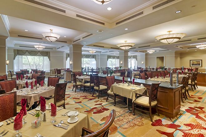 An elegant restaurant dining room with neatly arranged tables and chairs, adorned with sophisticated decor and soft lighting.