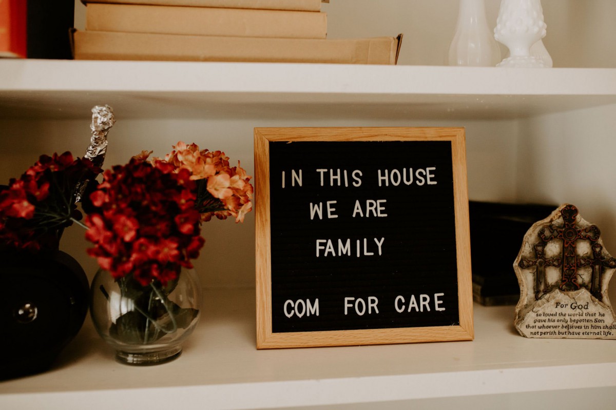 A cozy home display with a heartfelt message on a letter board next to a vase of flowers.