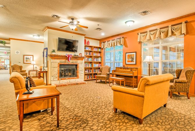 Cozy living room with a fireplace, bookshelves, and comfortable seating.