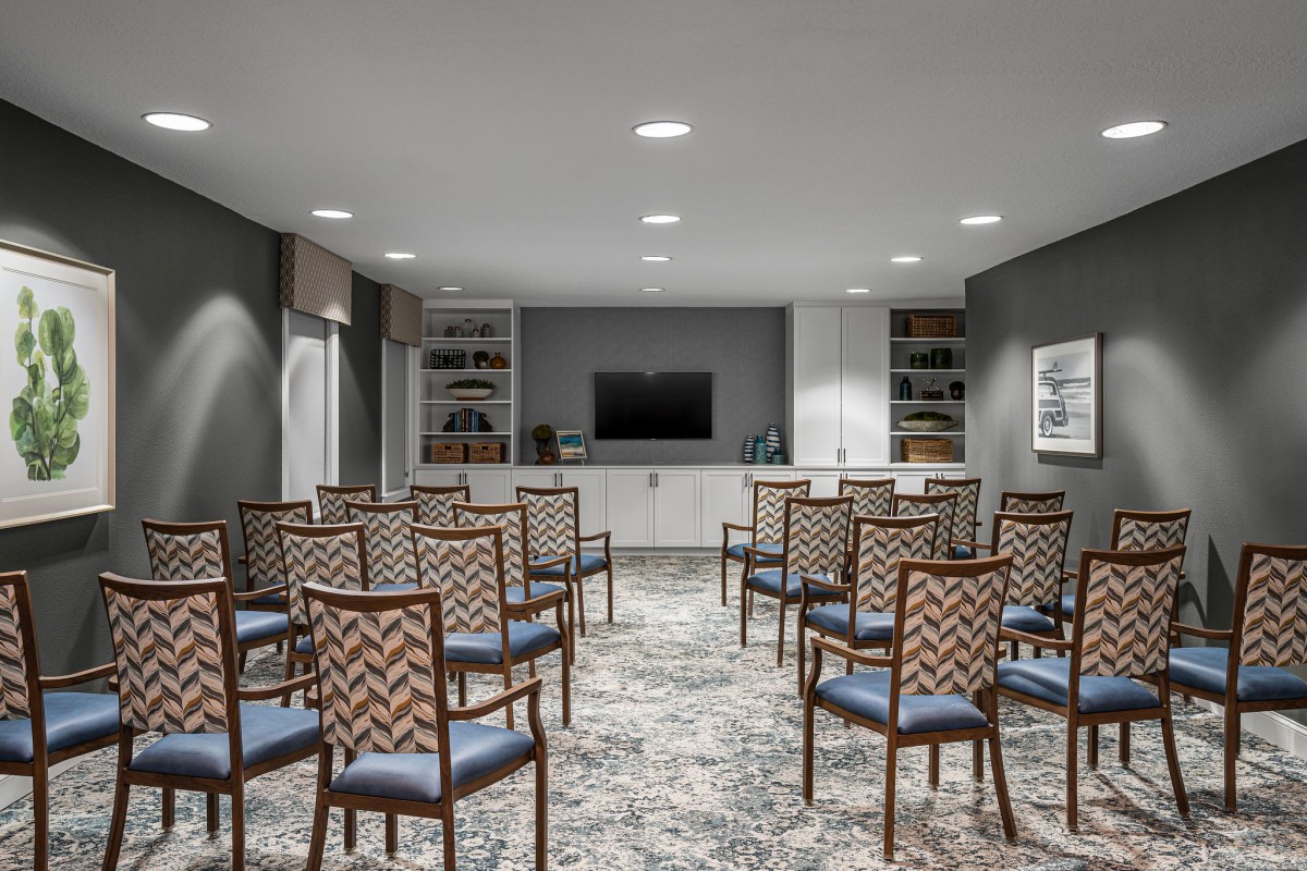 A well-organized conference room with rows of chairs facing a television for presentations.