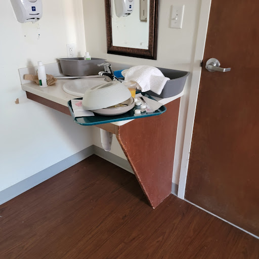 A bathroom area featuring a sink and various items on a cluttered countertop.