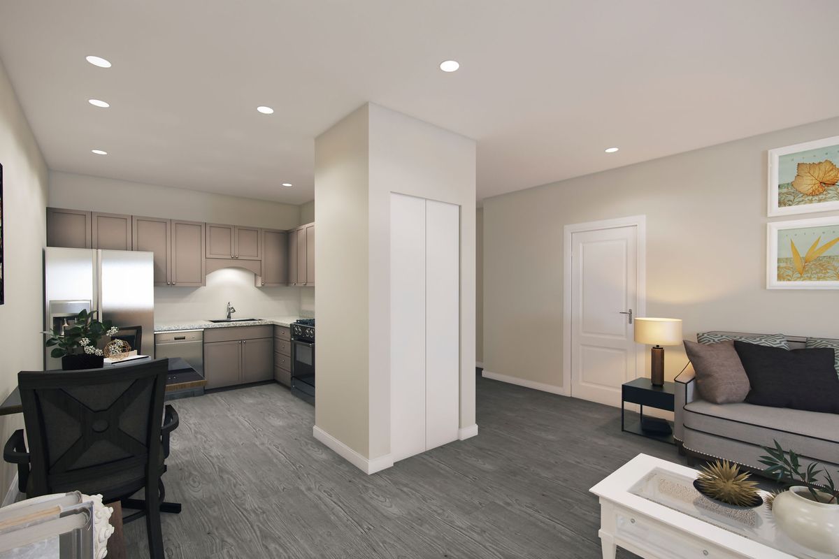 A modern apartment interior featuring an open kitchen and living room area with plush carpeting and contemporary furnishings.