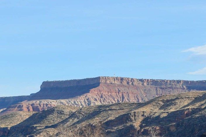 A scenic view of a mesa with clear blue skies in the background.