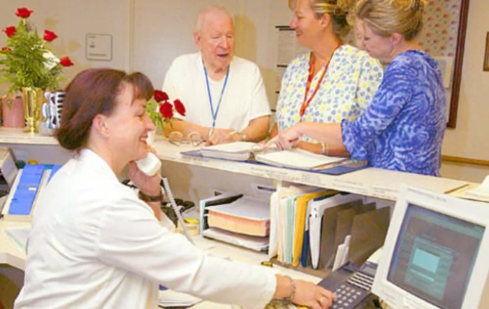 Hospital staff interacting at a reception desk.