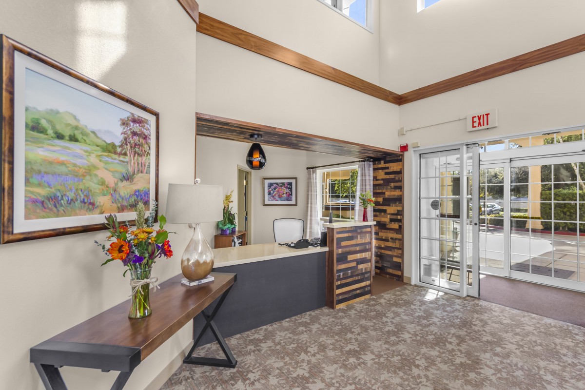 A cozy and well-decorated reception area featuring a desk, floral arrangement, and welcoming decor.