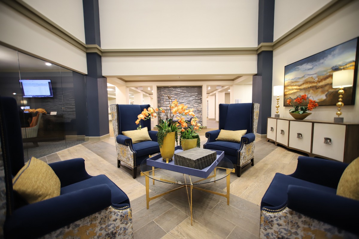 A modern lobby with elegant blue chairs and a central table adorned with decorative elements.