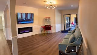 A modern living room with a TV and fireplace, featuring a popcorn machine and comfortable seating.