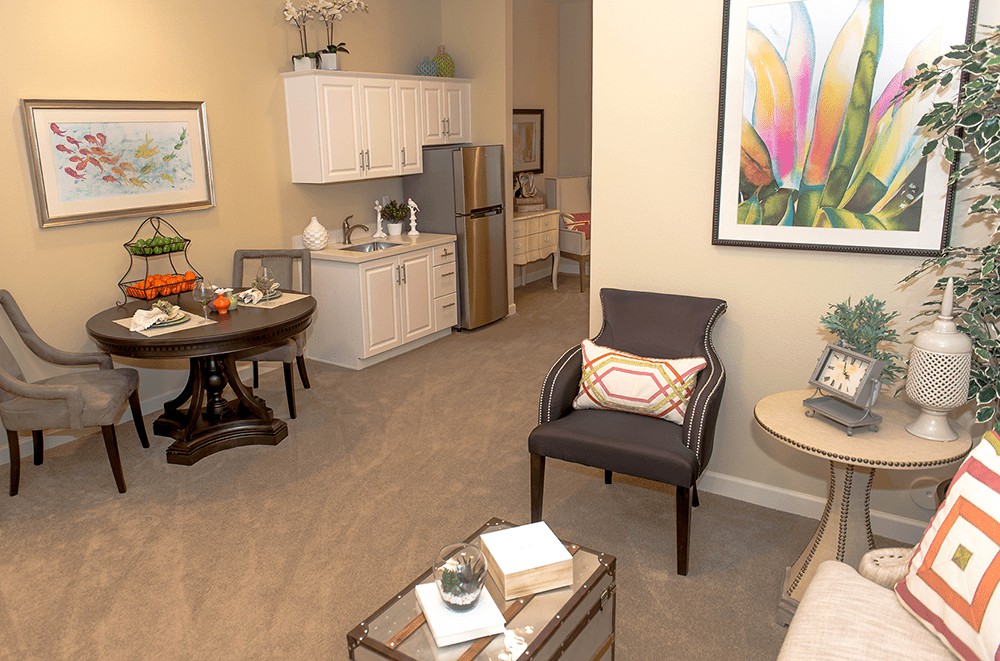 A cozy apartment interior featuring a small kitchenette and living area.
