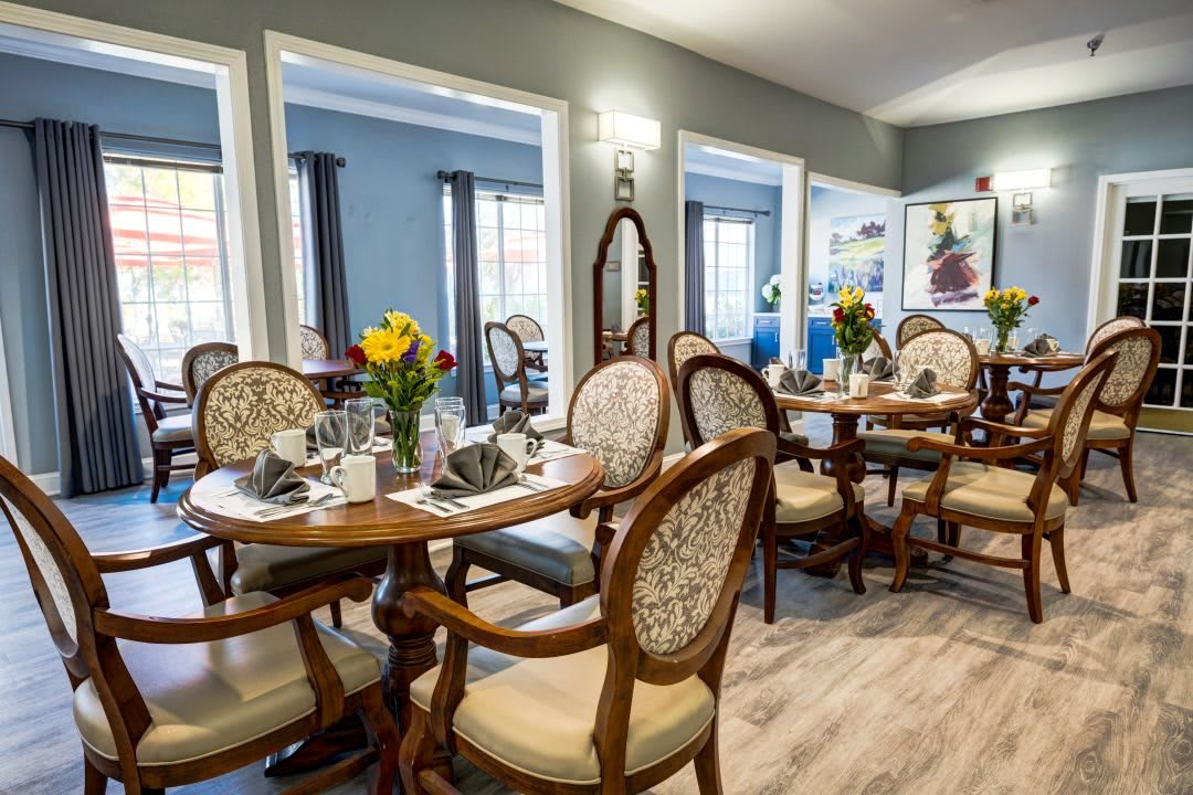 An elegant dining room with beautifully set tables and classic chairs.