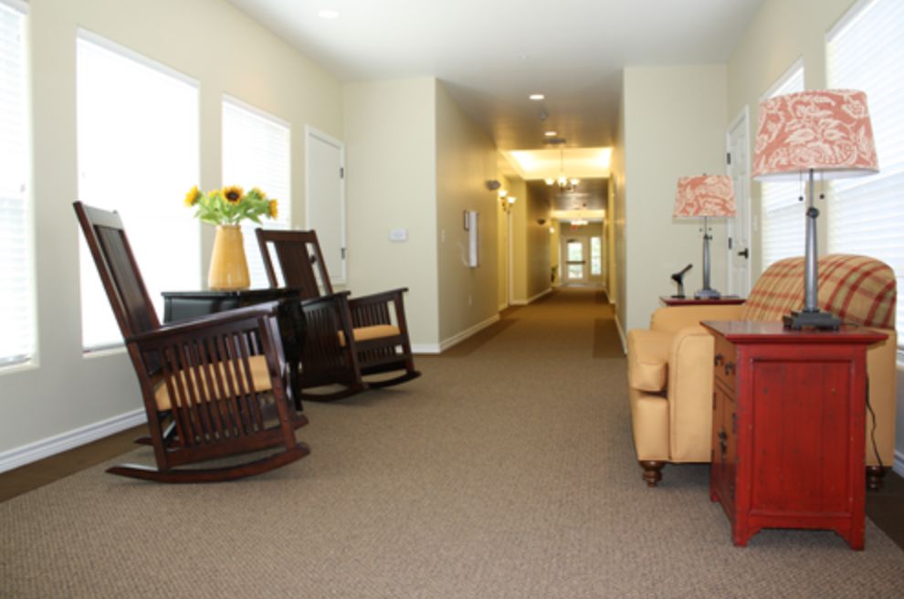 A cozy hallway featuring rocking chairs and a sofa with decorative elements.