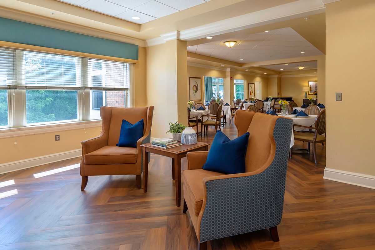 A cozy seating area with two armchairs and a small table in a well-lit room.
