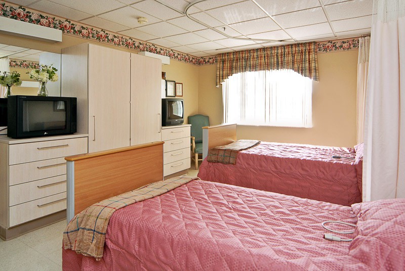 A cozy bedroom with twin beds and a television.